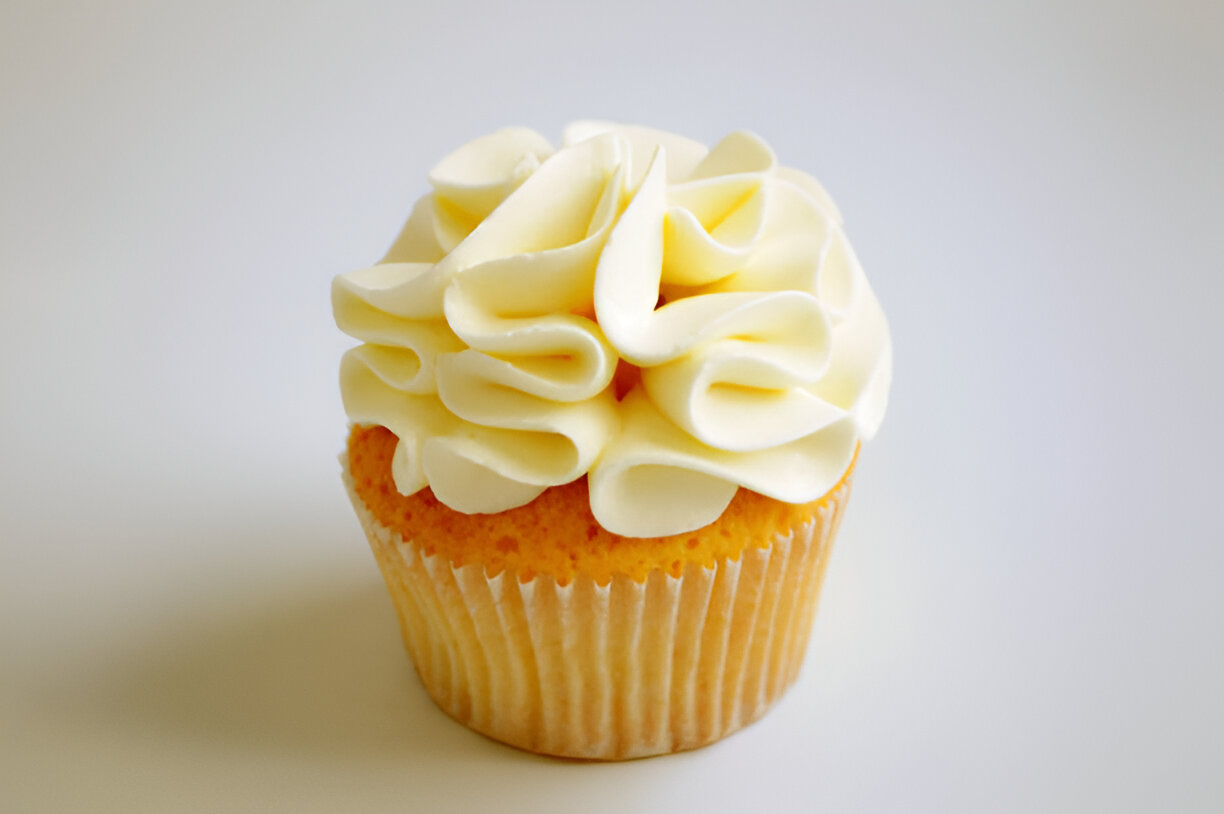 A beautifully decorated cupcake with a swirl of white frosting on top.