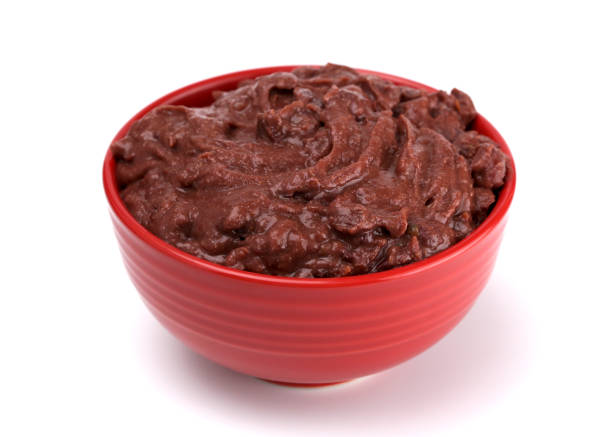 A red bowl filled with a thick, dark brown paste-like substance.