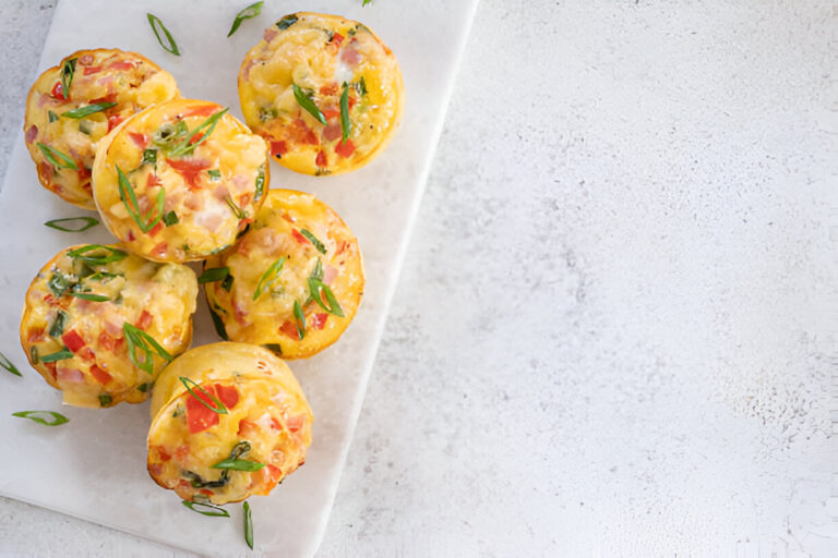 A platter of delicious veggie and ham muffins garnished with green onions.