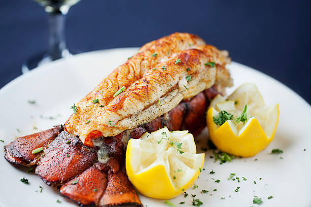 Delicious lobster dish with lemon wedges on a white plate.