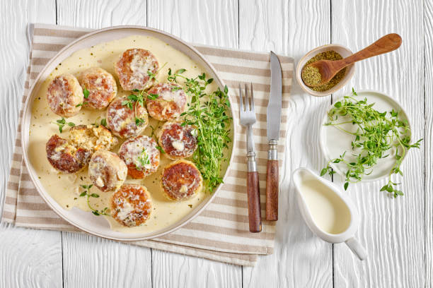 Plated savory baked goods topped with cheese, surrounded by fresh herbs and condiments.