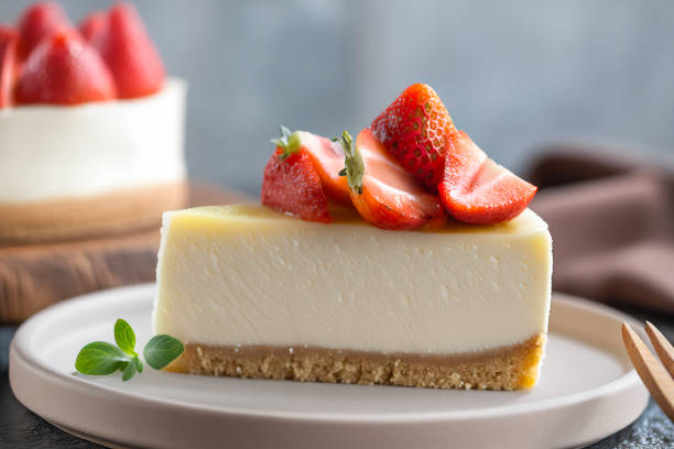 Slice of cheesecake topped with fresh strawberries on a beige plate