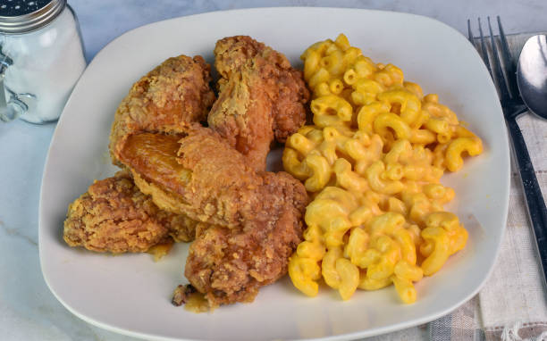 A plate of crispy fried chicken wings served with creamy macaroni and cheese.
