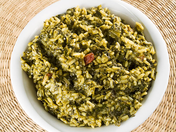 A bowl of cooked rice mixed with green leafy vegetables.