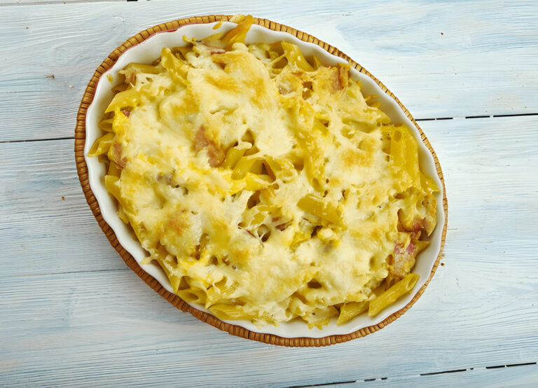 Baked pasta dish with melted cheese on top, served in a white oval baking dish.