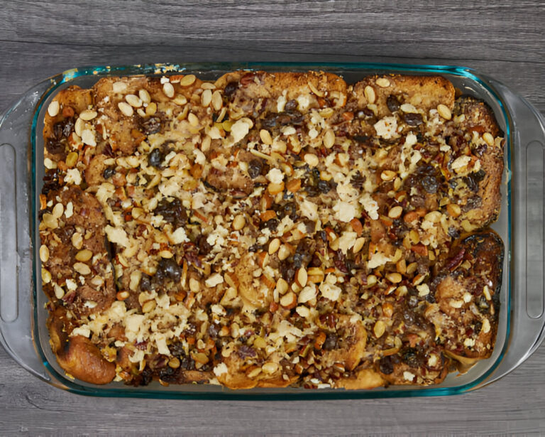 Baked casserole topped with a mix of nuts and seeds in a glass dish