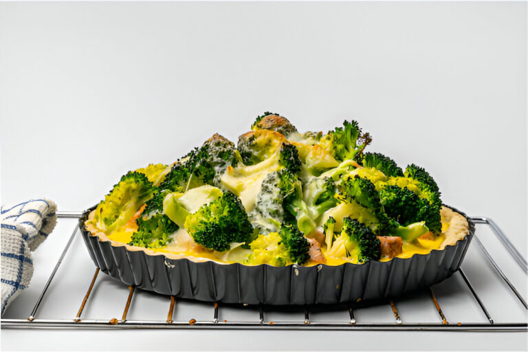 A savory broccoli and cheese tart on a wire rack, with a kitchen towel nearby.
