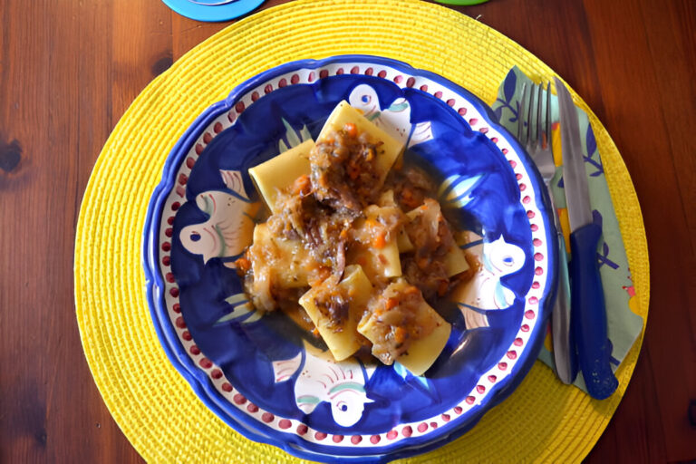 A colorful bowl of pasta topped with a meat sauce, served on a vibrant yellow placemat.