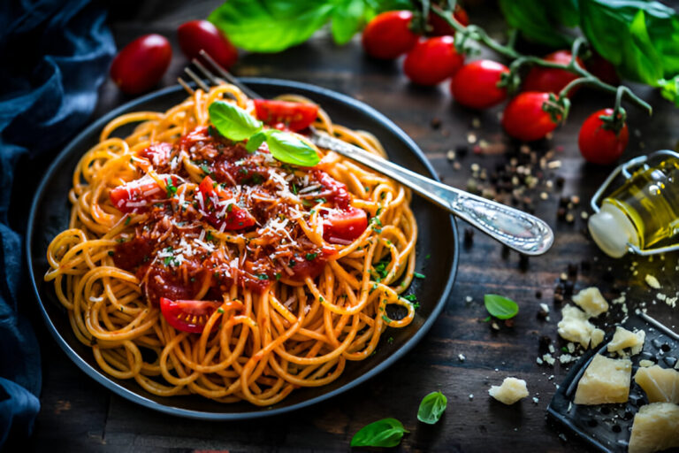 A delicious plate of spaghetti topped with tomato sauce, fresh basil, and grated cheese, surrounded by cherry tomatoes and olive oil.