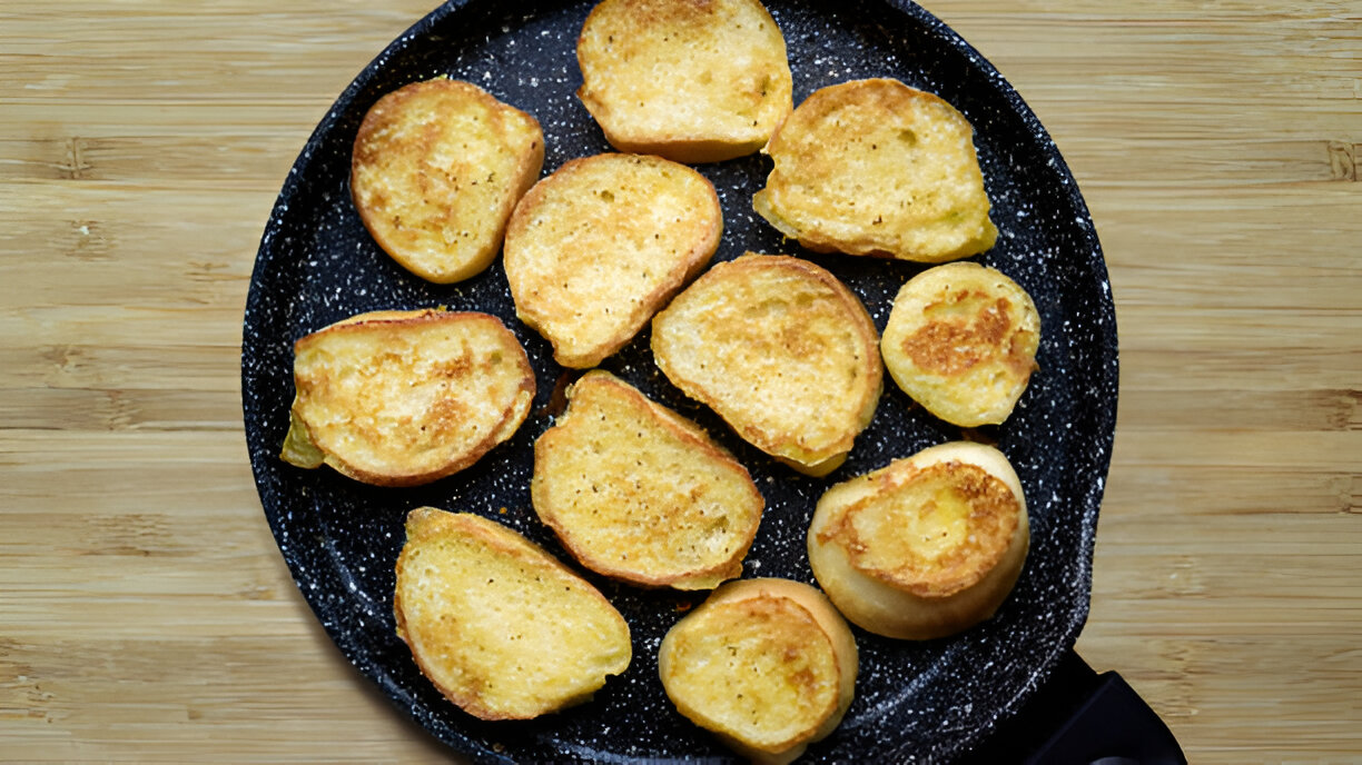 A skillet filled with golden-brown toasted bread slices.