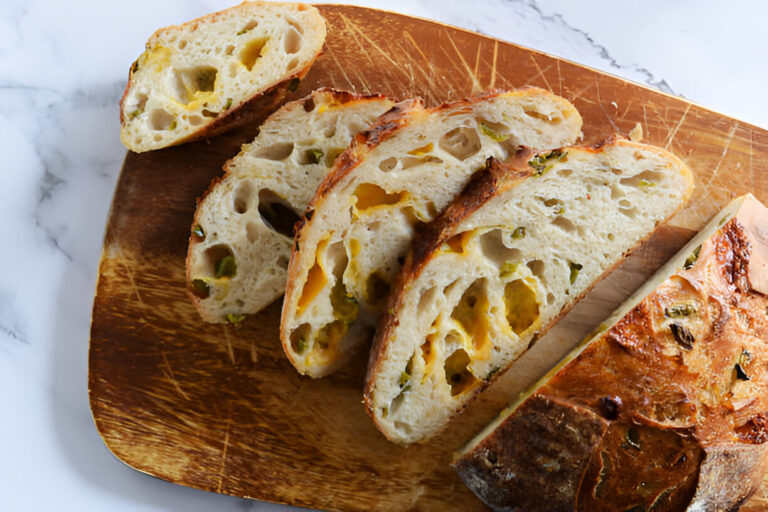 Sliced artisan bread with visible ingredients on a wooden cutting board
